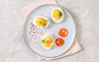 Выложите половинки яиц на тарелку, дополните нарезкой овощей, украсьте зеленью.