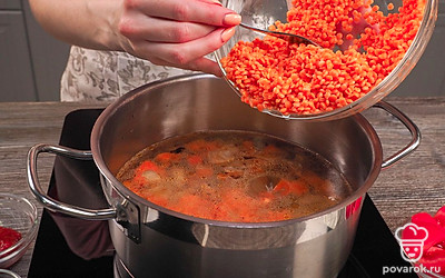 Сварите суп. Положите в кастрюлю зажарку из овощей, налейте воду, добавьте чечевицу и перемешайте. Поставьте кастрюлю на огонь, дайте закипеть и сделайте огонь минимальным, варите 20 минут.