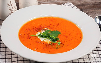 Горячий крем-суп из чечевицы налейте в порционные тарелки и добавьте ложечку сметаны.