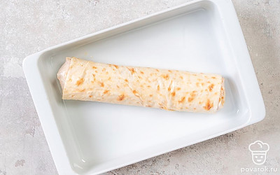 Сверните лаваш с начинкой в плотный рулет. Переложите в форму. Сверху смажьте рулет взбитым яйцом. Поставьте в духовку и запекайте 25-30 минут.