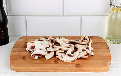 Нарежьте шампиньоны тонкими ломтиками.