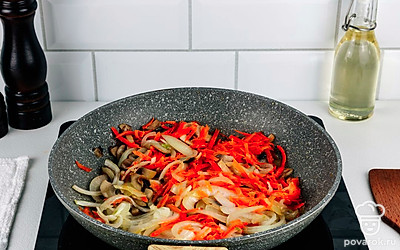 Тем временем разогрейте сковороду и влейте растительное масло. Выложите в сковороду репчатый лук и обжарьте его до золотистого цвета 5 минут. Затем добавьте морковь и шампиньоны. Пассеруйте овощи и грибы на небольшом огне 10 минут.