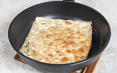 Смешайте воду с солью и перемешайте. Разрежьте лаваш на две равные части по размеру сковороды. Разогрейте сливочное масло в сковороде на среднем огне. Обмакните лаваш в воду, чтобы он стал мягким и упругим, но не разваливался. Поместите лаваш на разогретую сковороду и обжаривайте примерно 30 секунд на среднем огне.