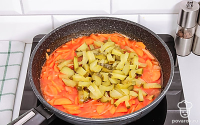 В сковороду добавьте томатную пасту и соленые огурцы, влейте огуречный рассол и перемешайте. Тушите 5 минут.