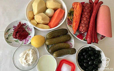 Подготовьте все ингредиенты. Для этого картофель отчистите и нарежьте небольшими кубиками. Варите их в кастрюле до готовности. Лук очистите и мелко нарежьте. Морковь также очистите и натрите на терке. Мясную продукцию нарежьте мелко, так же нарежьте и огурцы.