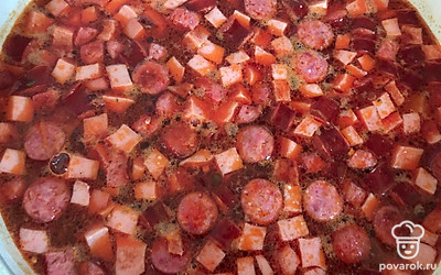 Тушите все еще 10 минут и все содержимое сковородки добавьте в кастрюлю с картофелем. Варите все на среднем огне около 25-30 минут. Подавайте солянку горячей с маслинами, лимоном и сметаной.