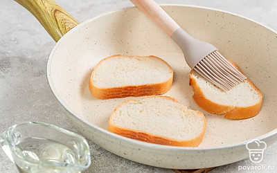 Смажьте ломтики хлеба маслом с одной стороны. Масляной стороной положите на разогретую сковороду. Смажьте маслом вторую сторону.