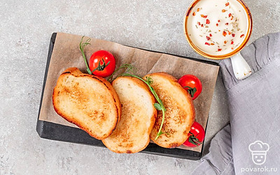 Натрите горячие хрустящие гренки чесноком и сразу же подавайте на стол.