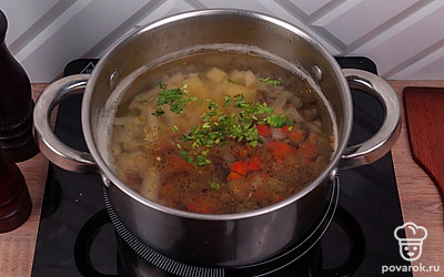 После того, как вода закипит, добавьте в кастрюлю пережарку и свежую зелень. Посолите и поперчите по вкусу. Перемешайте, снова доведите до кипения и убавьте огонь.