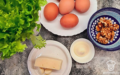 Отварите яйца до полной готовности. Сыр натрите на средней терке. Грецкие орехи нарубите.