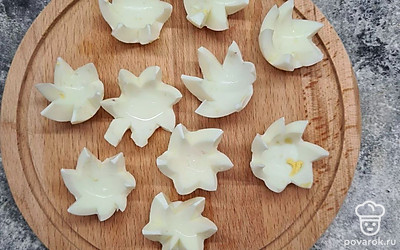 Яйца почистите и разрежьте пополам. Уберите желток и из белков вырежьте ножом цветочки.