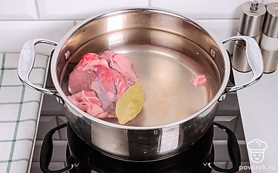 Залейте мясо 2 литрами воды, положите лавровый лист и поставьте на огонь. Дождитесь кипения и убавьте огонь. Варите бульон около получаса.