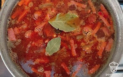 В кастрюле доведите до кипения бульон и отварите в нем картофель. Когда картофель будет готов, отправьте в кастрюлю обжаренные колбасы с маслинами и огурцами. Добавьте лавровый лист, соль и перец по вкусу и варите еще 5 минут.