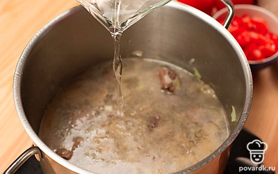 Влейте в кастрюлю к мясу воду, доведите до кипения и снимите пену шумовкой. Затем добавьте в бульон рис и помидоры, варите 20 минут на медленном огне. Добавьте ткемали, хмели-сунели, соль, перемешайте и оставьте на огне еще на 5 минут.