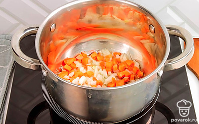 Разогрейте растительное масло в кастрюле с толстым дном и обжарьте лук и морковь в течение 5 минут на среднем огне до золотистого цвета.