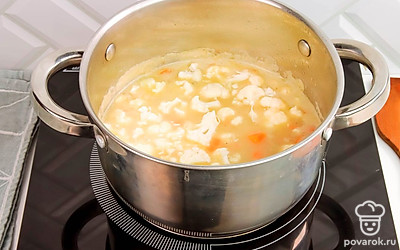 Добавьте в кастрюлю цветную капусту, воду и рис. Варите суп на медленном огне примерно 10-15 минут до полной готовности риса.