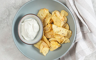 Остудите готовые чипсы, выложите в глубокую тарелку и подайте к столу. Дополнить закуску можно любым соусом, например, чесночным.