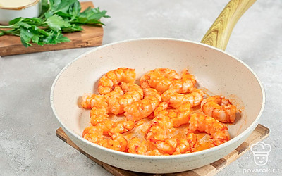 Мелко нарубите зубчики чеснока или пропустите через пресс. Влейте в сковороду масло и поставьте на огонь. Когда масло нагреется, выложите креветки. Обжаривайте морепродукты в течение 3 минут. Затем добавьте к ним чеснок и перемешайте. Готовьте ингредиенты еще несколько минут до золотистости чеснока.