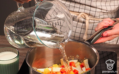 Приготовьте суповую основу. Содержимое кастрюли залейте горячей водой, жидкость должна полностью покрыть овощи. Когда вода закипит, убавьте огонь до минимального и варите овощи 30 минут.