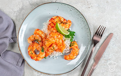 Подавайте жареные креветки с чесноком вместе с отварным рисом. В качестве дополнения блюда используйте соевый соус — он сделает вкус креветок еще интереснее.