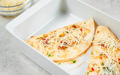 Закончите приготовление. Полейте готовые лепешки с начинкой оставшимся соусом из сальсы, а также посыпьте полутвердым сыром. Готовое блюдо отправьте в духовку на 8-10 минут, чтобы сыр подрумянился.