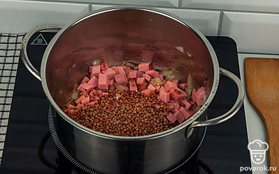 Гречневую крупу промойте и добавьте к вареной колбасе и луку.