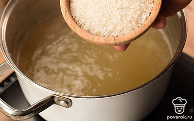 Готовое мясо нарежьте на небольшие кусочки. Процедите бульон и варите в нем рис в течение 10 минут.