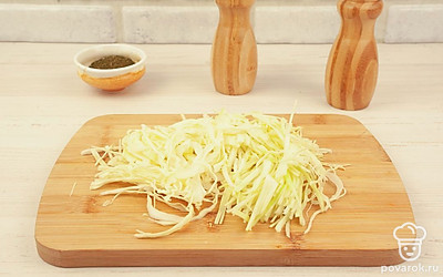 Нашинкуйте белокочанную капусту – ломтики должны быть тонкими и примерно одинакового размера. Натрите на крупной терке морковь.