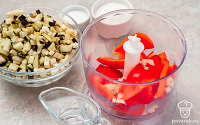 Подготовьте овощи. Баклажаны нарежьте небольшими кубиками, замочите в соленой воде и отожмите влагу. Болгарский и острый перец и чеснок измельчите блендером до однородности.