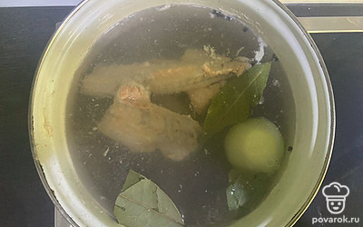 Когда вода закипит, снимите пенку. Добавьте в воду лавровый лист, луковицу, перец горошком, соль по вкусу. Варите бульон на медленном огне полчаса.