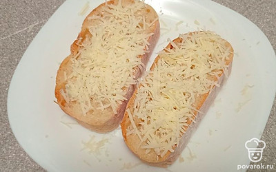 На ломтики чиабатты выложите тертый пармезан и поставьте в разогретую духовку. 