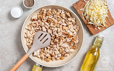 Начните готовить жульен. Нарежьте филе небольшими кубиками, а грибы — ломтиками. Сыр натрите на терке. Обжарьте курицу на масле минуты 4, пока она не побелеет. После чего всыпьте грибы и жарьте 10 минут до готовности шампиньонов.