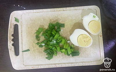 Вареное яйцо почистите и разрежьте пополам.