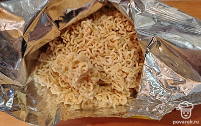 Возьмите пачку лапши быстрого приготовления (70 граммов), разломайте ее на части. Специи нам не понадобятся.