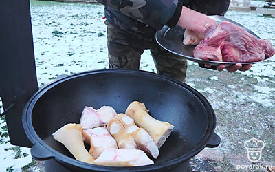 На дно казана выложите говяжьи ноги.