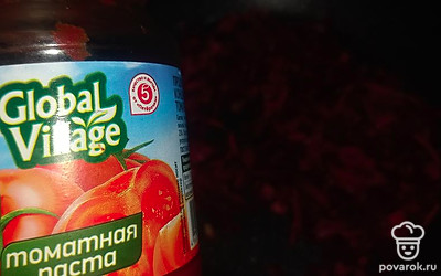 Добавьте в зажарку томатную пасту, немного воды. Тушите минут 5 на небольшом огне.