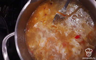 Непрерывно помешивая суп, влейте тонкой струйкой яйцо.