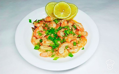 Отварите рис, выложите с помощью кулинарного кольца на плоскую тарелку, сверху положите небольшое количество готовых креветок, полейте все соусом от креветок. Лук промойте под проточной водой, дайте стечь воде, нарежьте на мелкие колечки и посыпьте им блюдо, рядом положите несколько долек лимона или лайма.