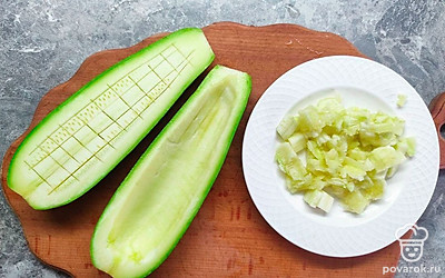 Подготовленные кабачки или цукини, с помощью острого ножа, разрежьте пополам, после аккуратно сделайте ножом внутри надрезы, но не доходите до шкуры овоща. Затем достаньте ложкой мякоть кабачка и нарежьте ее на маленькие кусочки.