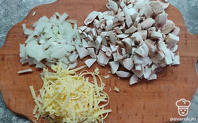 Очищенные грибы мелко нарежьте. Репчатый лук мелко нарежьте. Твердый сыр натрите на крупной терке. Хорошенько разогрейте сковородку на плите, влейте растительное масло, затем обжаривайте нарезанный лук с грибами до полной готовности, постоянно помешивайте ингредиенты.
