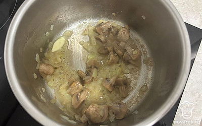 Шампиньоны разрежьте на четвертинки. Обжарьте вместе с луком еще 5 минут.