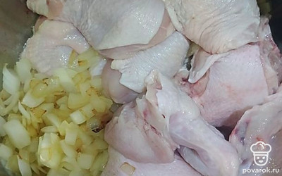 В кастрюлю положите топленое масло и репчатый лук. Сразу же отправьте туда курицу.