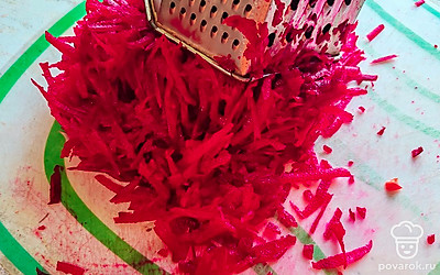 Свеклу натрите на терке. Добавьте ее в сковороду, перемешайте. Продолжайте тушить. 