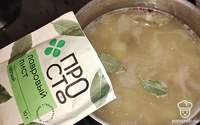 В кастрюлю налейте воду. Добавьте горох, куриные крылья, соль, перец, лавровый лист. Варите на среднем огне до полуготовности гороха.