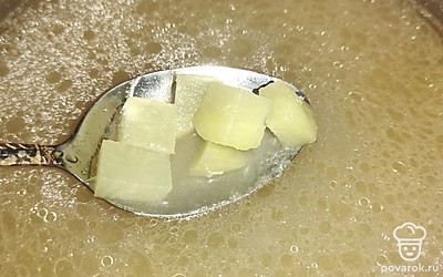 В куриный бульон добавьте пасту «Том Кха» и нарезанный картофель.