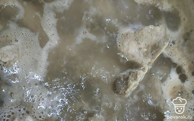 Затем слейте воду, промойте свиные косточки и варите мясо до закипания. 