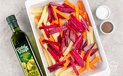 Приготовьте овощи. Порежьте одинаковой соломкой картофель «Выгодно и удобно», морковь и свеклу. Свеклу положите в отдельную емкость и сбрызните оливковым маслом Global Village. Оставьте на некоторое время. После смешайте с остальными овощами. Посолите. Выложите ровным слоем на противень и запекайте 20 минут, перемешав один раз.