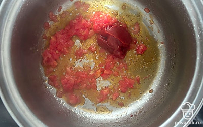 Помидор натрите на терке. Обжарьте на растительном масле вместе с томатной пастой в течение 1-2 минут.