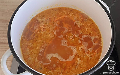 В кипящую воду опустить нарезанный некрупно картофель. Туда же выложить зажарку. Варить все вместе до полуготовности картофеля.