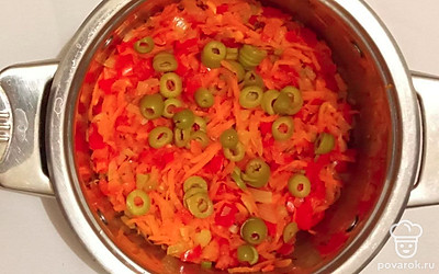 В кастрюле разогрейте растительное масло и обжарьте лук и морковь до мягкости. Затем добавьте помидоры, перец, сельдерей и оливки и протушите все вместе еще 5 минут.